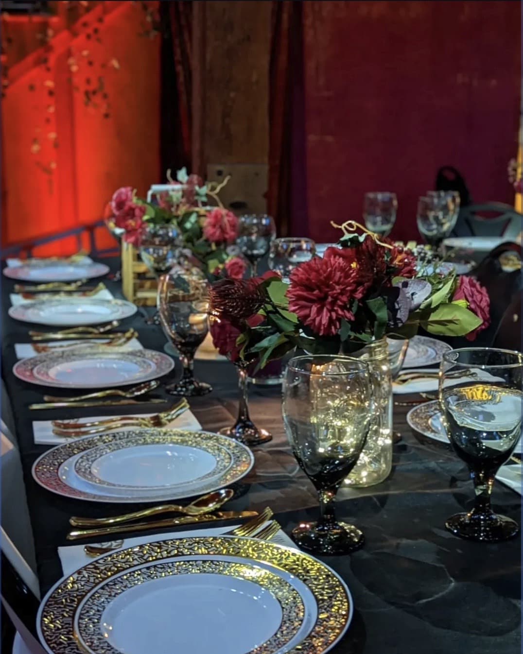 A table laid with white cloth, flowers and candles before a meal