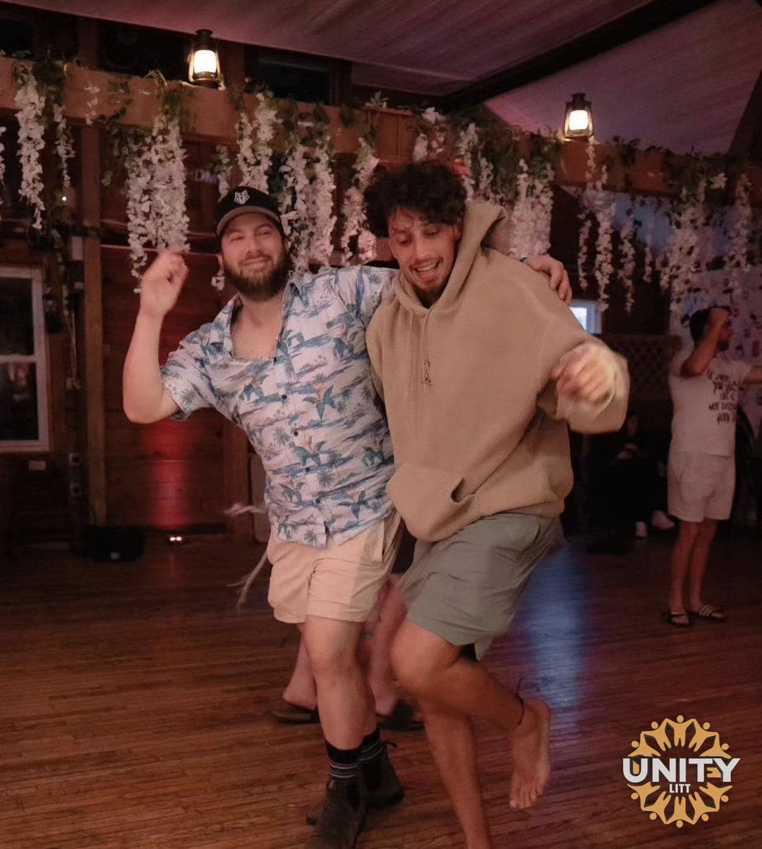 Friends dancing in a close circle, mid-motion