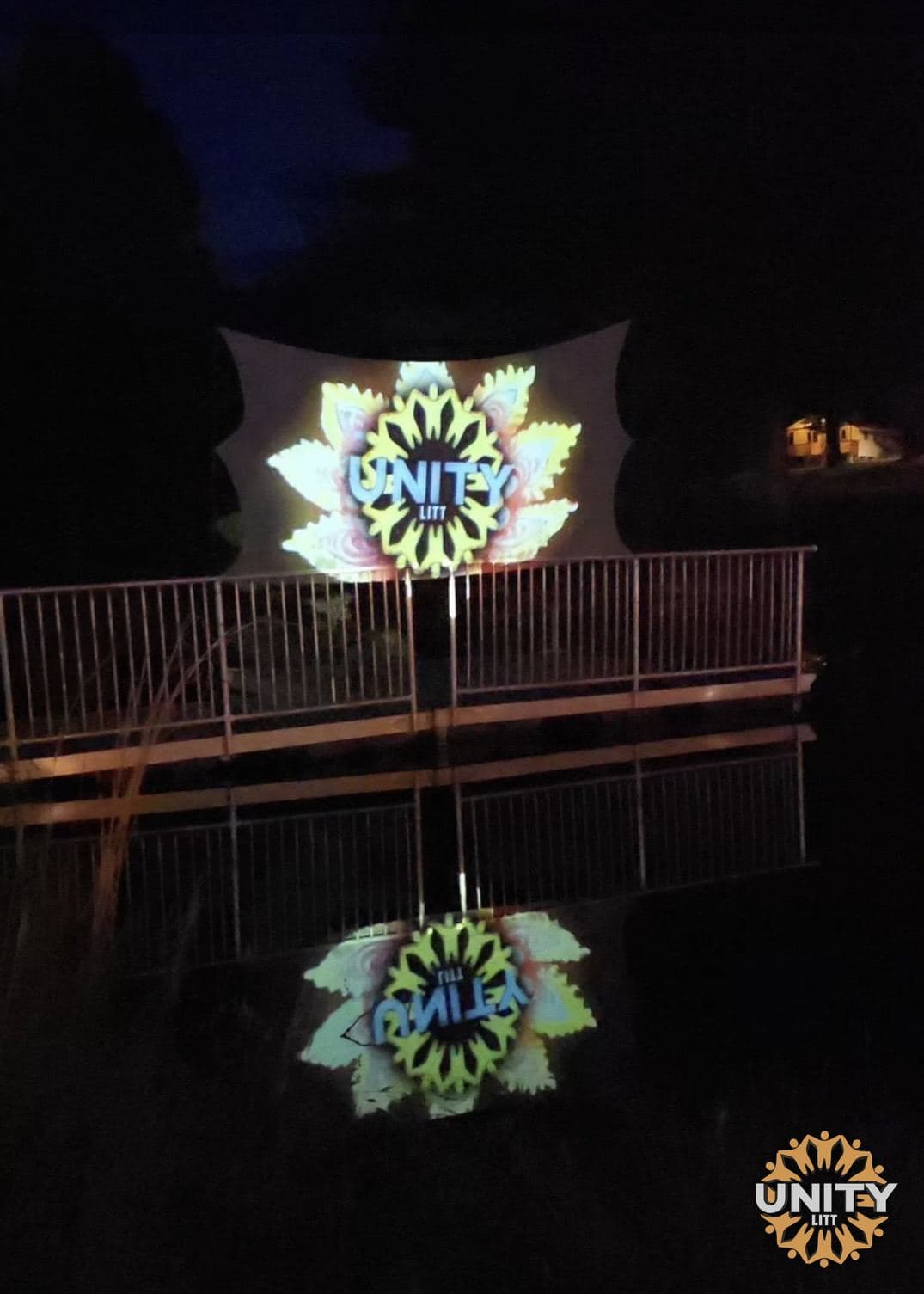 The UnityLitt name projected onto the side of a building at night