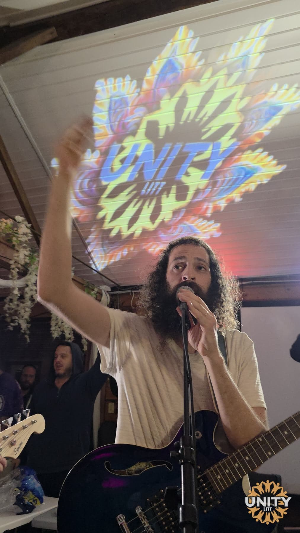 Two musicians playing together in front of a projected design