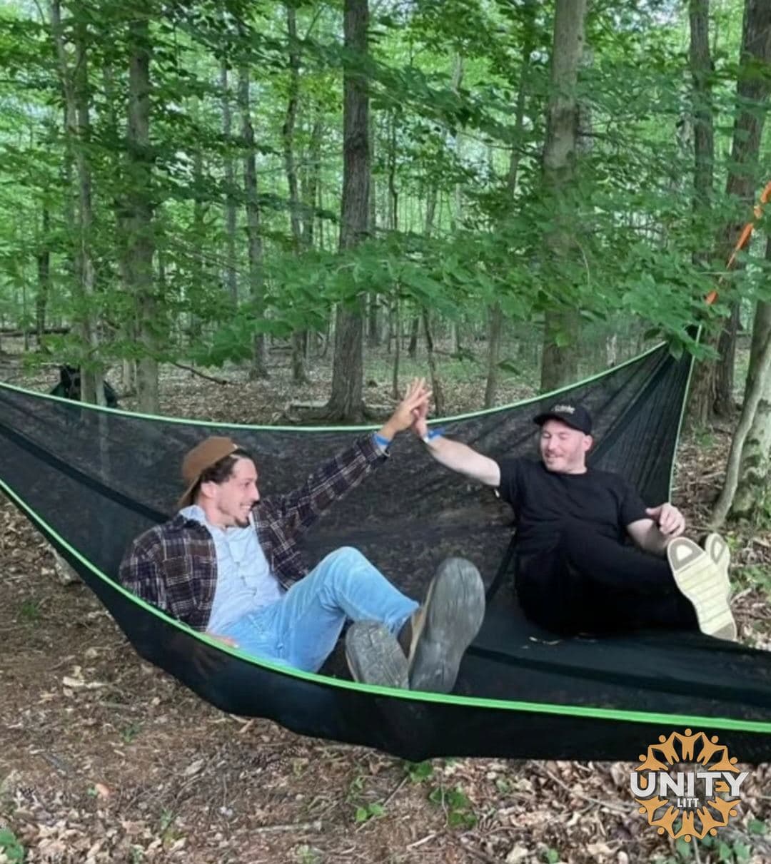 Two people talking in a hammock strung between trees