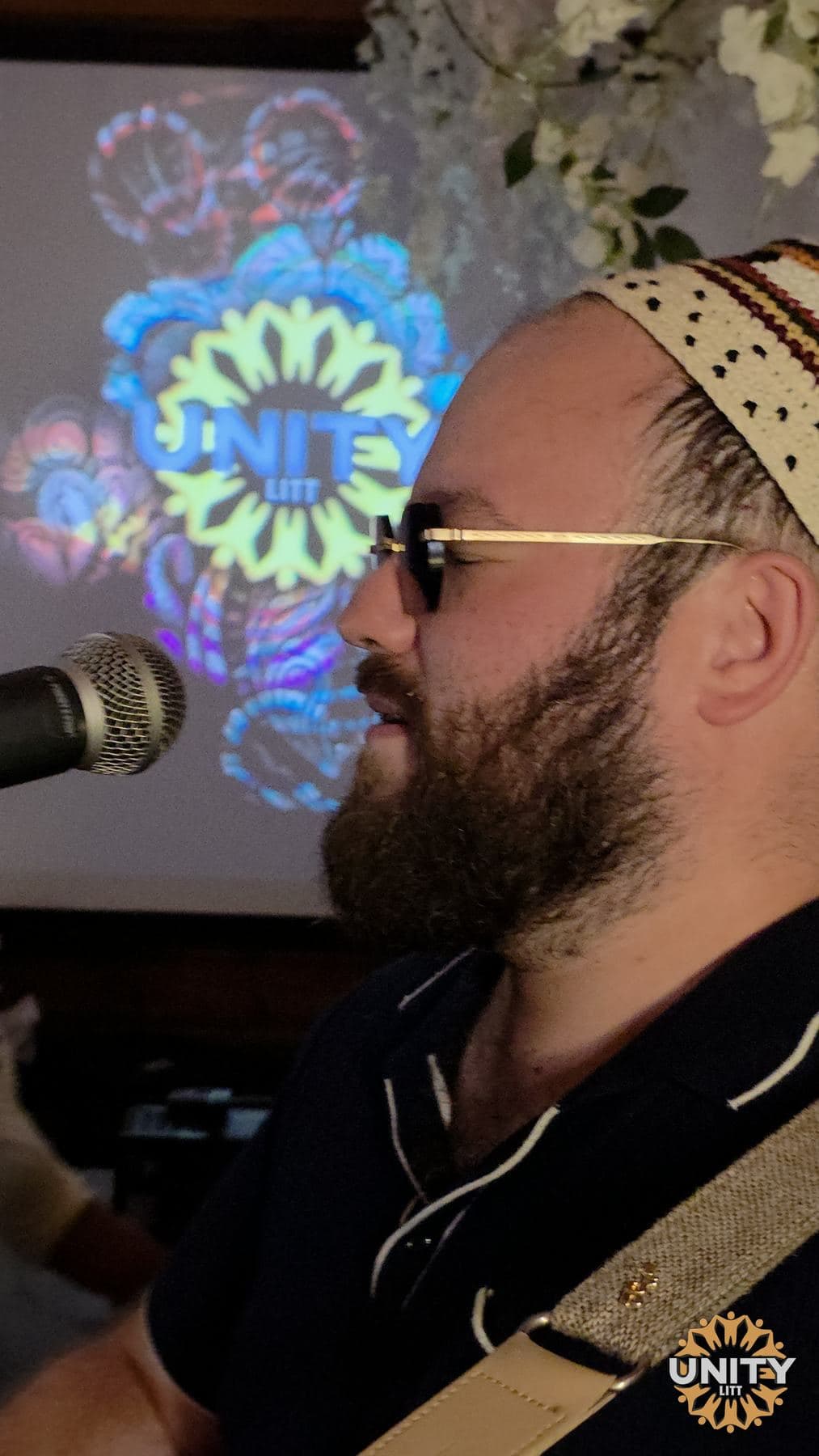 A singer leaning into the microphone against a projected pattern