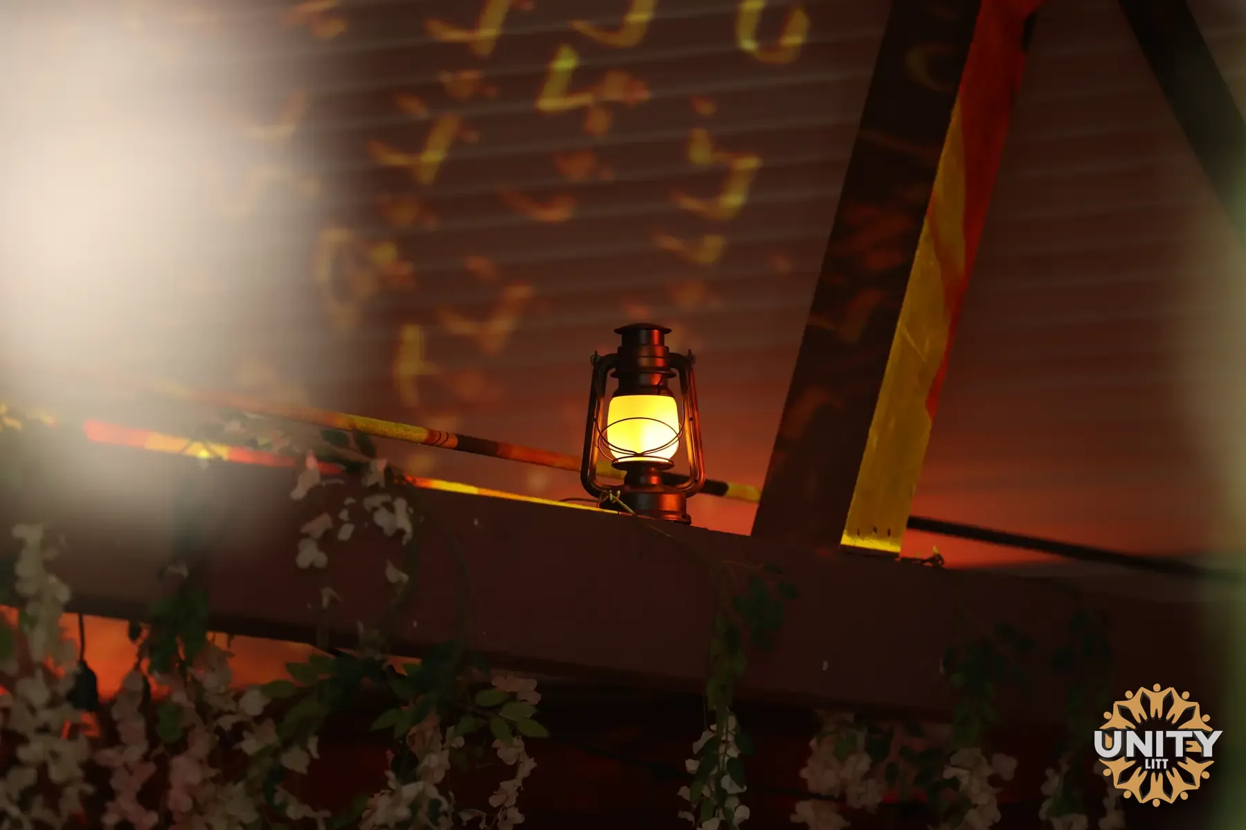A lantern on a wooden beam, letters of light glowing on the wall beyond